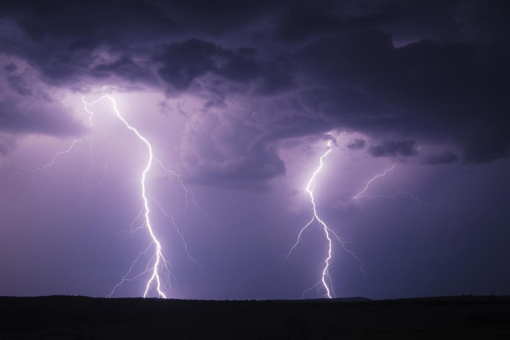 Dramatyczna burza z piorunami nad ciemnym krajobrazem, symbolizująca emocjonalne zawirowania w snach